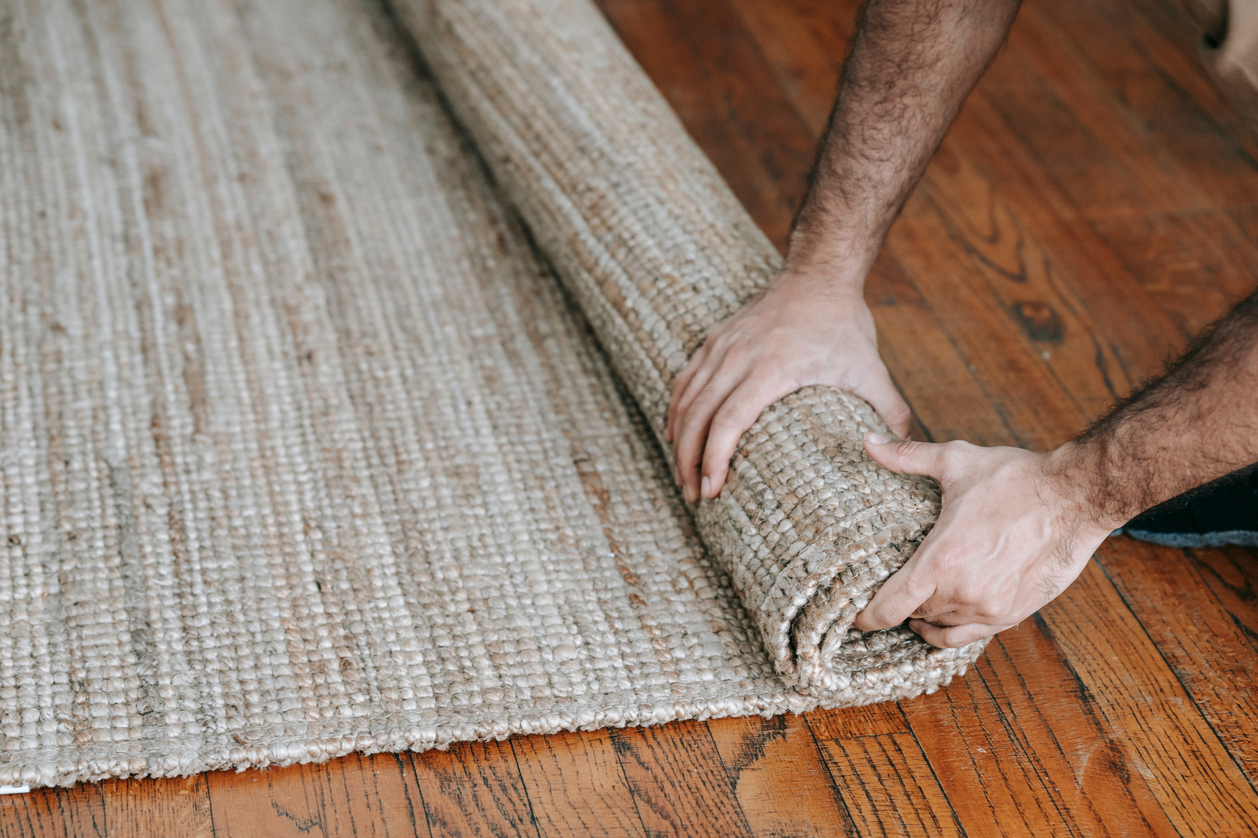 Person Packing Up A Carpet